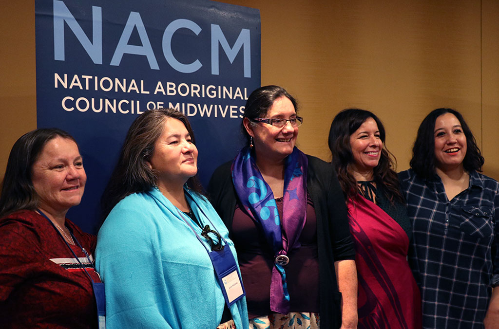 Indigenous midwives Joyce Leaf, Carol Couchie, Ellen Blais and Julie Wilson pose with Bear Clan Mother, Louise McDonald (second from left) after her plenary session presentation at the 2018 CAM Conference in Gatineau, Quebec.